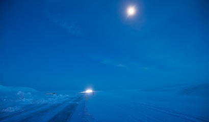 Månen lyser upp en isig vinterväg på Island Månen lyser upp en isig vinterväg på Island
