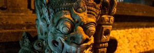 Demon staty i kvällsbelysning längs Sanur strandpromenad, Bali
