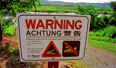 En skylt med varning för krokodiler i vattnet