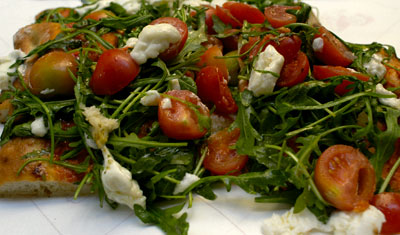 Äkta italiensk Pizza med tomater, ruccola och mozzarella