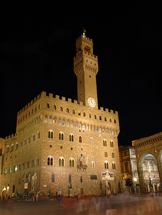 Torget Piazza della Signoria med Palazzo Vecchio vackert upplyst i mörkret