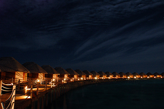 Vy över längan av watervillas nattetid