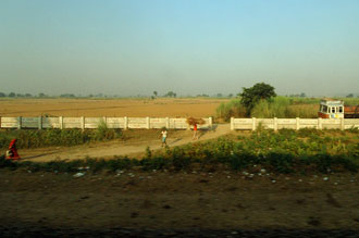 Utsikt över det indiska landskapet ifrån tåget mellan Delhi och Agra