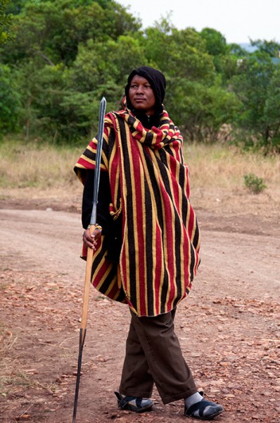Vakt lutar sig mot spjut på JK Mara Camp, Masai Mara Vakt lutar sig mot spjut på JK Mara Camp, Masai Mara