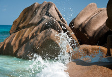 Vågor slår in vid klippor Grand Anse, La Digue Seychellerna