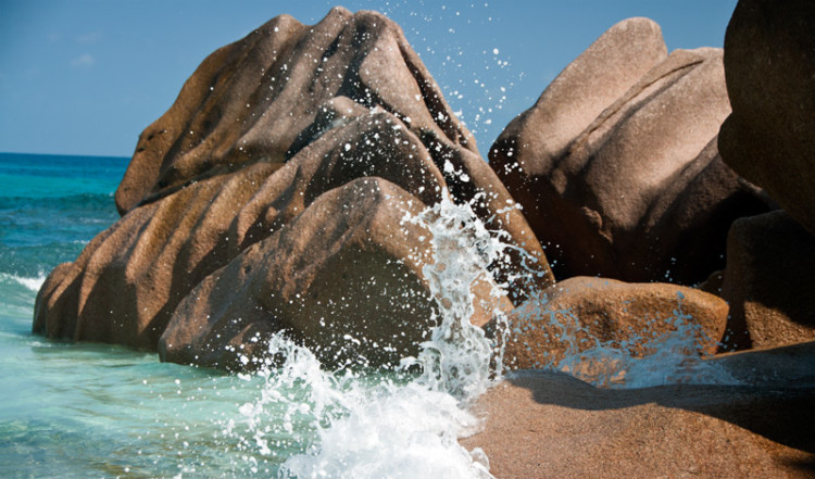Vågor slår in vid klippor Grand Anse, La Digue Seychellerna