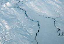 Vattendrag genom snötäckt landskap på Island