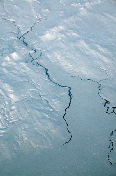 Vattendrag genom snötäckt landskap på Island