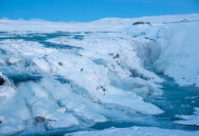 Vattnet tränger genom isen vid Gullfoss, Island
