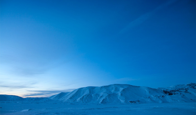 Berg i ett isländskt vinterlandskap upplysta av månljus