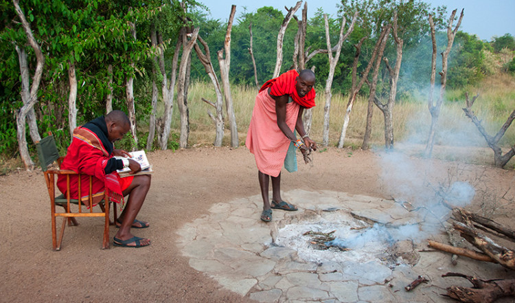 Masaj gör upp lägereld på JK Mara Camp, Masai Mara Kenya