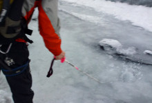 Guiden leder undan smältvatten på glaciären Sólheimajökull, Island