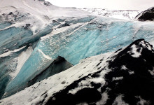 Glaciären med blåskimrande is på Sólheimajökull, Island