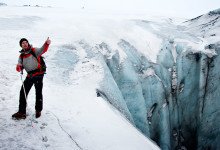 Guiden vid djupt hål i glaciären vid Sólheimajökull, Island
