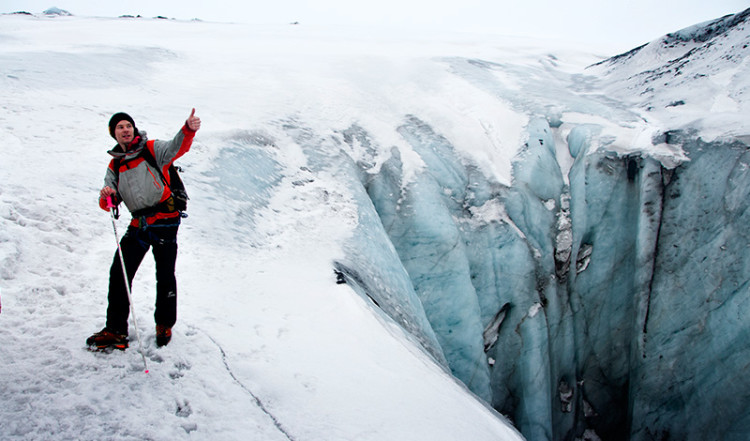Guiden vid djupt hål i glaciären vid Sólheimajökull, Island