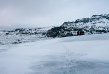 Gruppen samlar sig och ser ut över glaciärtungans slut Sólheimajökull, Island