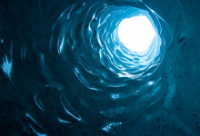 Hål genom glaciären sett underfrån i en isgrotta, Sólheimajökull, Island