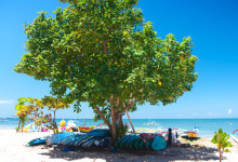 Surfbrädor och båtar vid Sanur strandpromenad, Bali