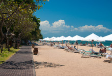 Rader av parasoll och solstolar på Sanur strandpromenad, Bali