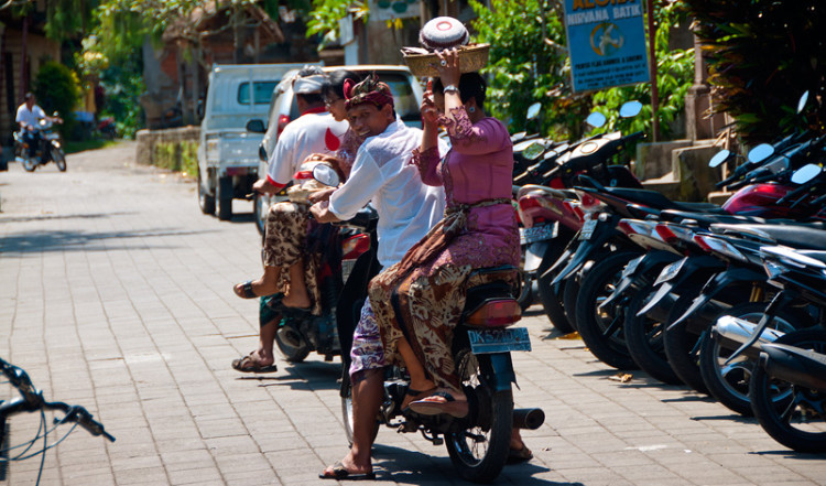 Kvinnor med mat på huvudet på mopeder, Ubud Bali Kvinnor med mat på huvudet på mopeder, Ubud Bali