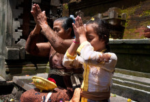 En äldre kvinna och ung flicka ber tillsammans, Tirtha Empul Tempel, Bali