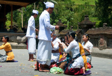 Män skvätter vatten på bedjande kvinnor vid Pura Tirtha Empul, Bali