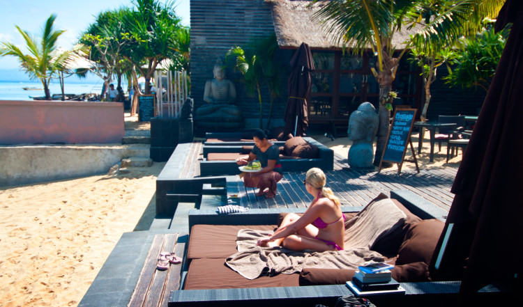 Personalen placerar ut offergåvor vid strandentren till Indiana Kenanga Villas, Lembongan