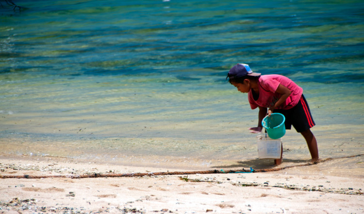 Lokal pojke vid stranden vid Indiana Kenanga Villas, Nusa Lembongan, Bali