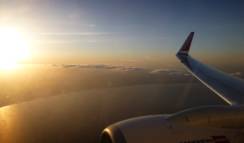 Solnedgång från molnen i ett Norwegian plan mot Spanien