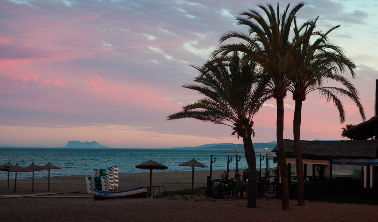 Vacker solnedgång över Estepona med Gibraltar klippan i bakgrunden