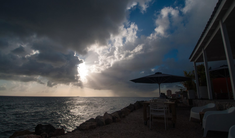 Dramatisk himmel under solnedgång, sett från baren till Bijblauw Hotel i Willemstad