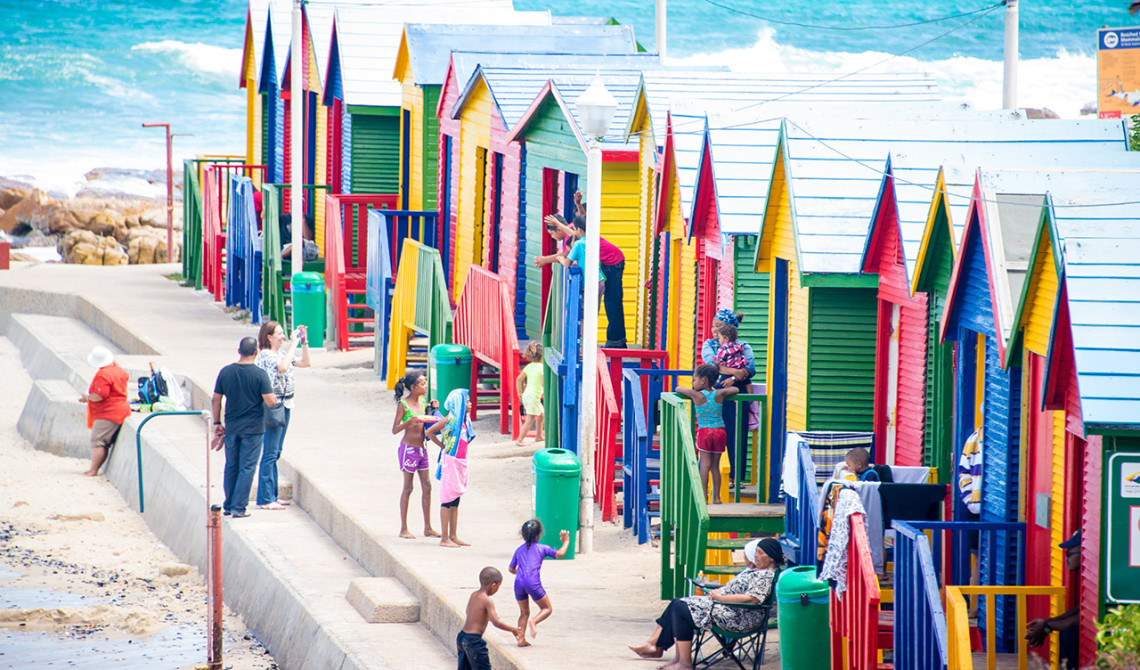 Färgglada strandhus utmed kustvägen och False Bay i Sydafrika