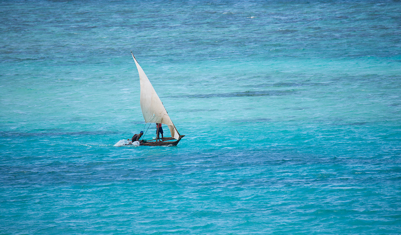 Båt som passerar ute i havet utanför stranden till Manta Resort
