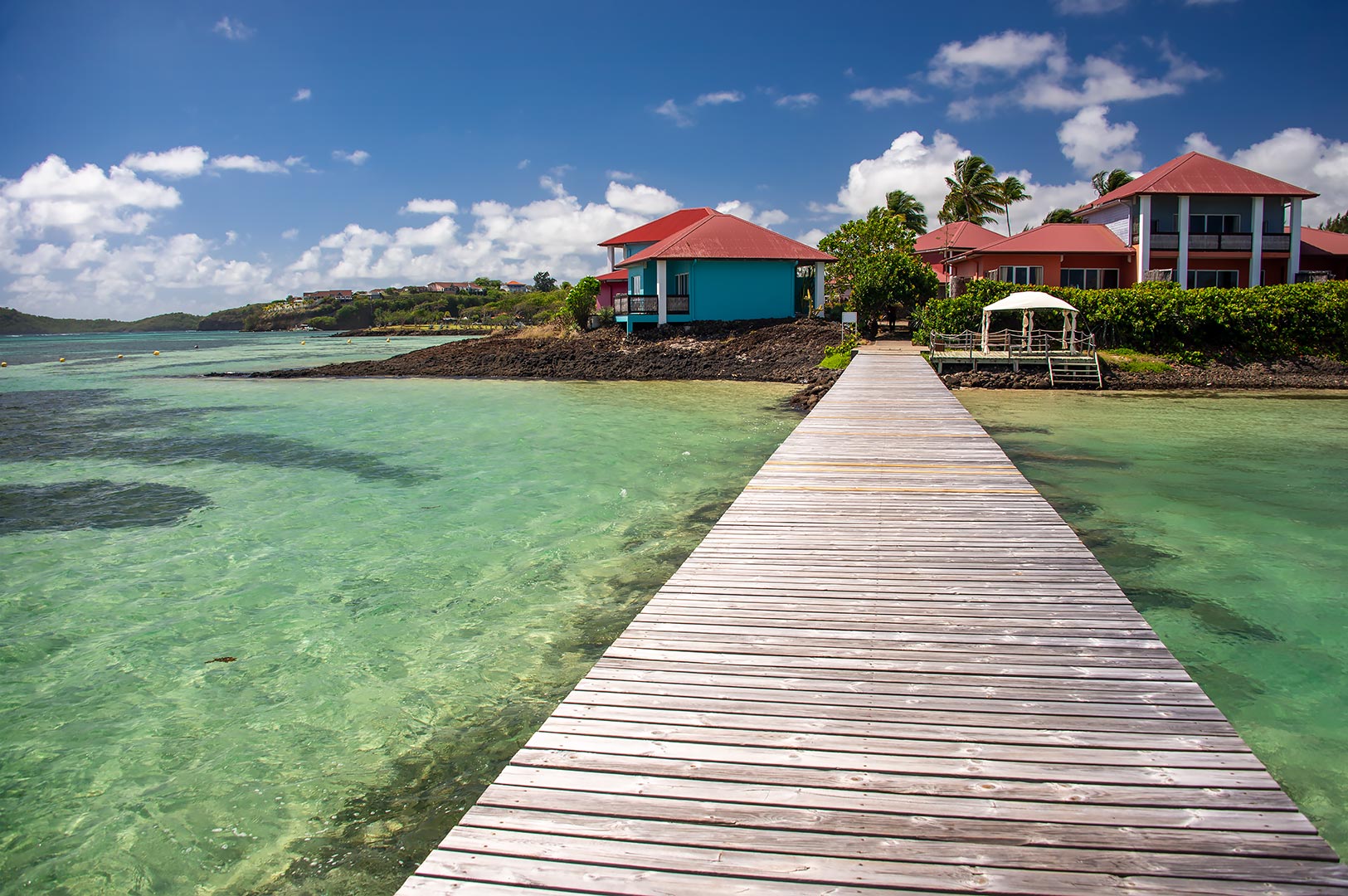Lång brygga ut i lagunen vid Le Cap Est Lagoon Resort, Martinique